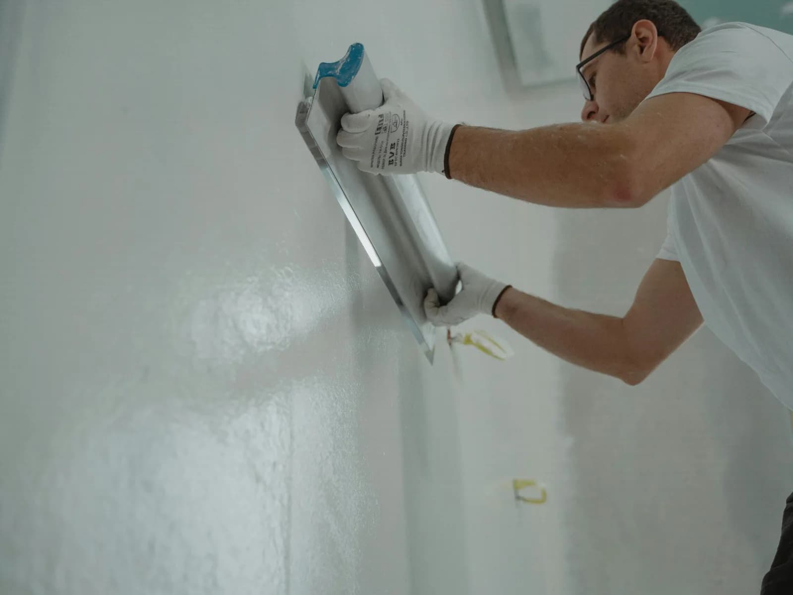 Maler bereitet eine Wand mit Spachtel vor