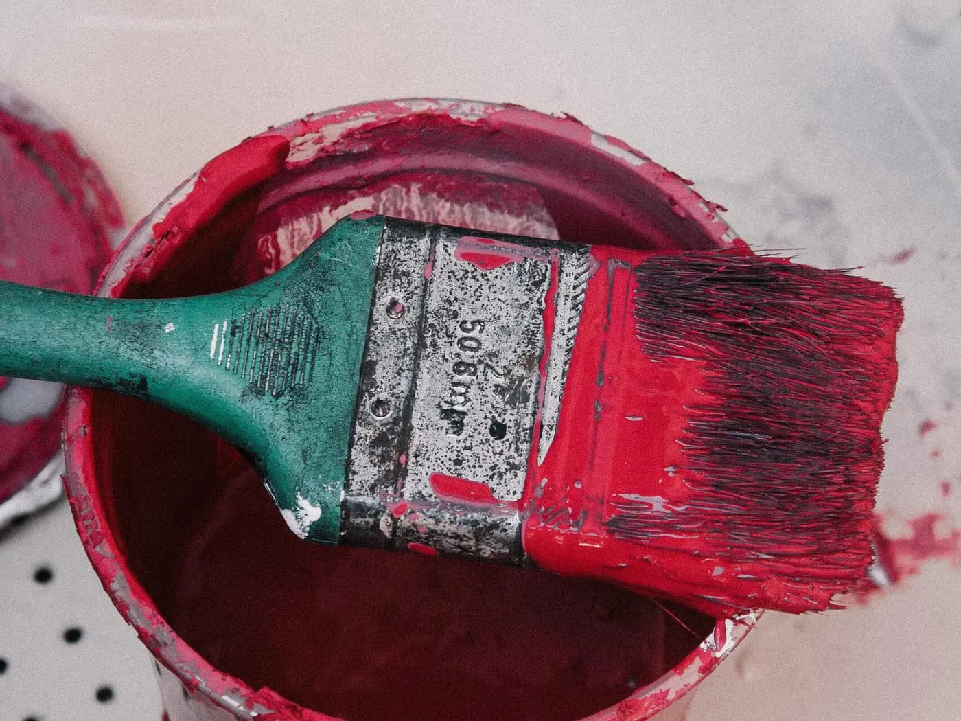 Pinsel und Farbeimer mit roter Farbe